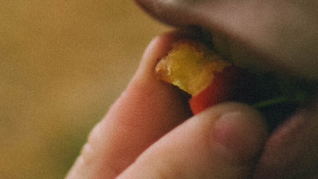 Close-up of a person bringing a bite of food to their open mouth.